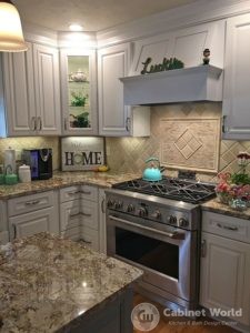 White Kitchen Cabinetry with Custom Hood Range and Stainless Steel Appliances